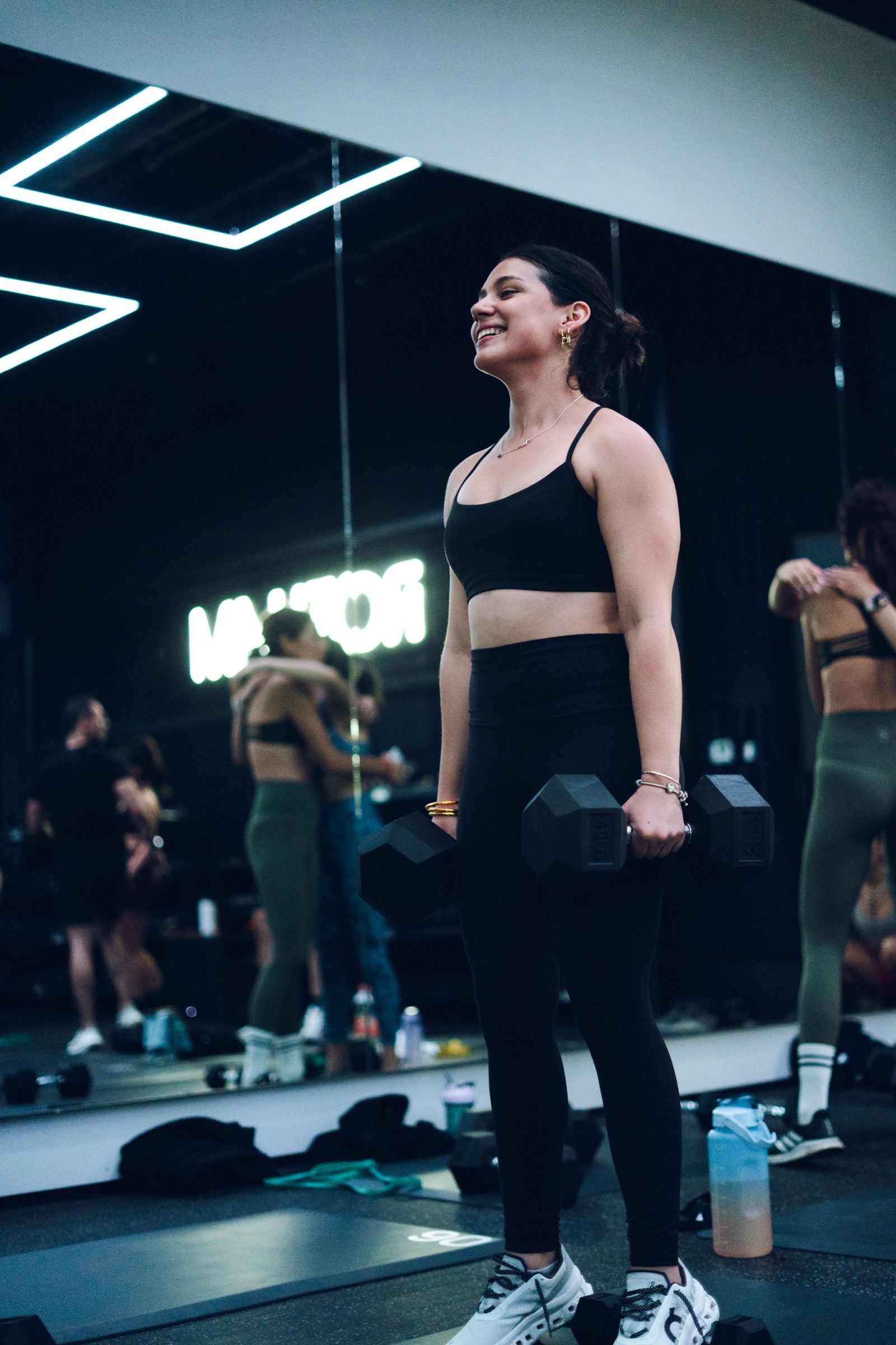 Participante entrenando fuerza con mancuernas durante Bootcamp en ROTHAM