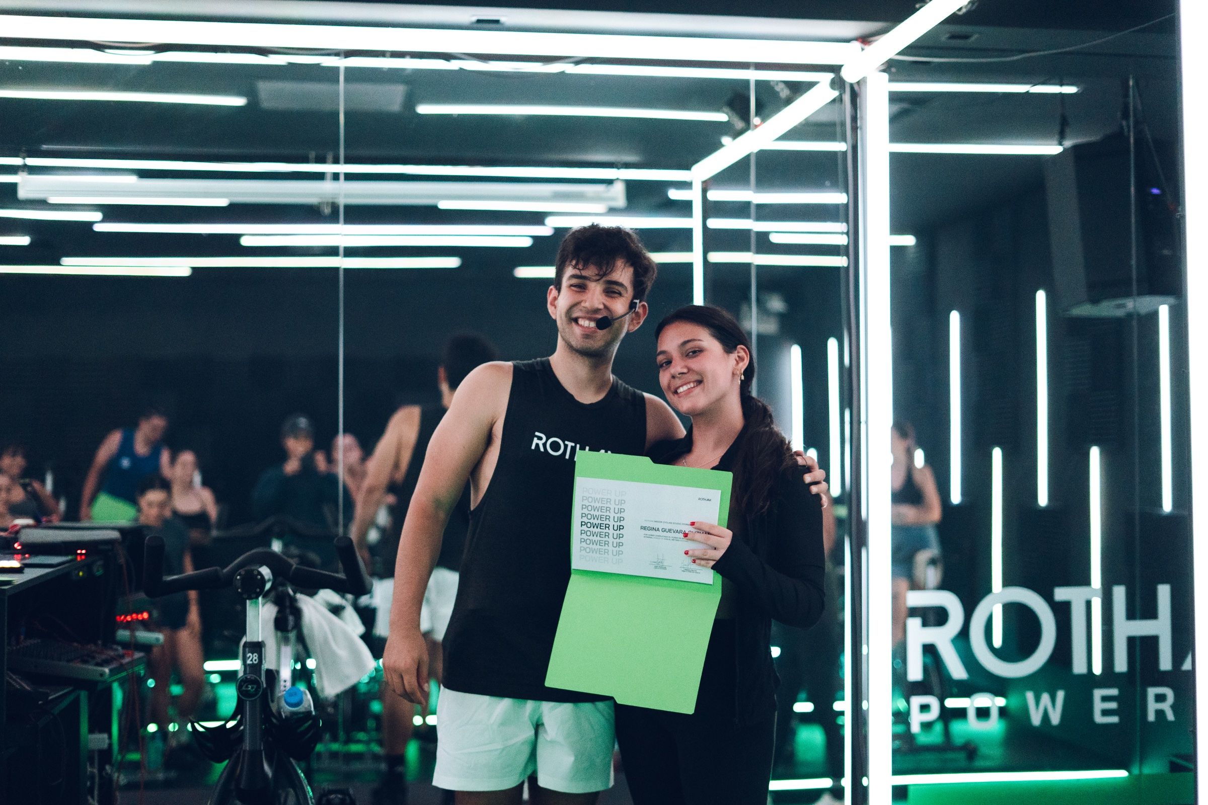 Coach y participante con su reconocimiento al cerrar Power Up